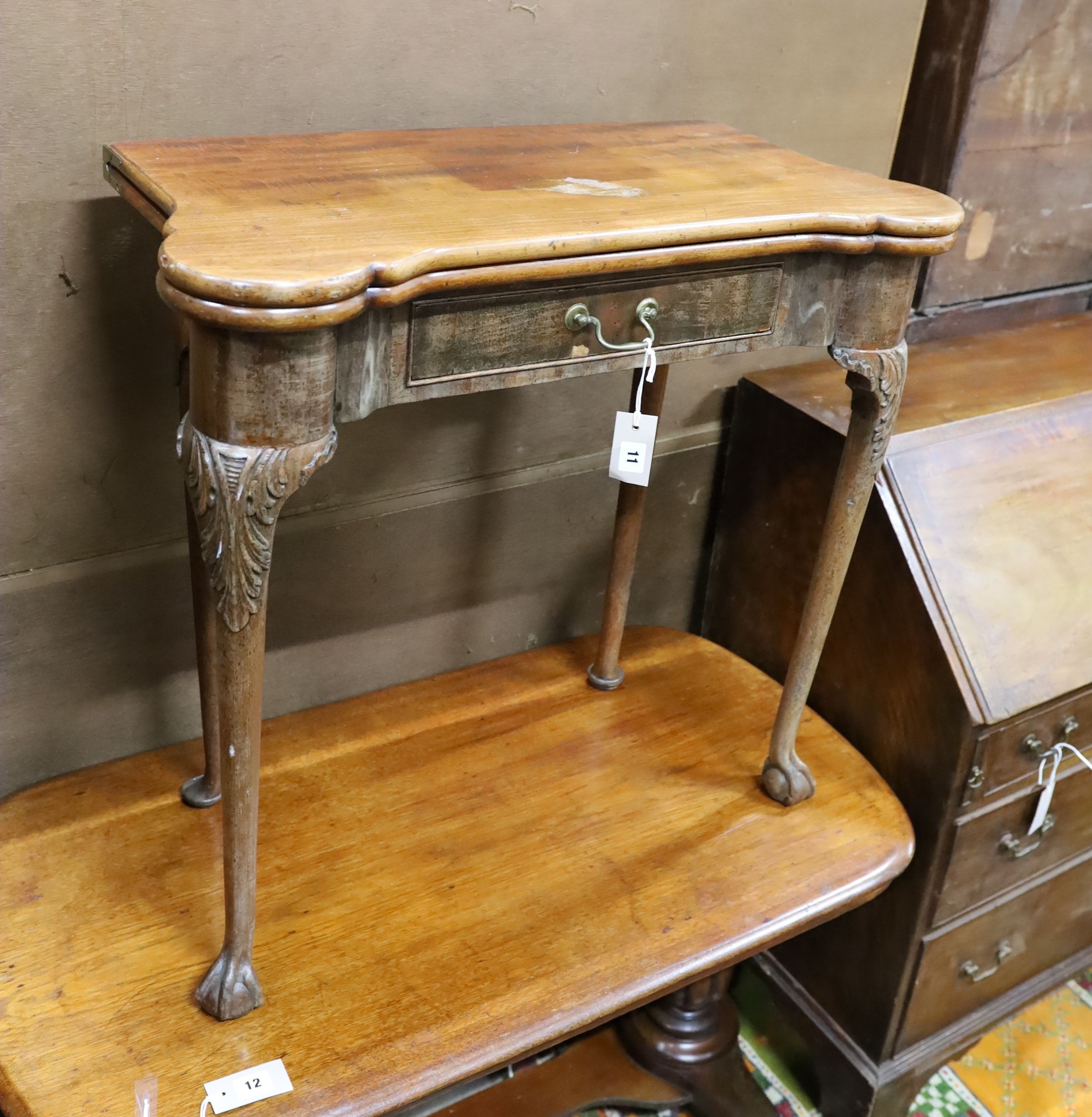 A George II mahogany folding card table on carved cabriole legs, width 76cm, depth 38cm, height 72cm